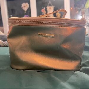 Bronze colored Jennifer Lopez cosmetic bag with carrying strap